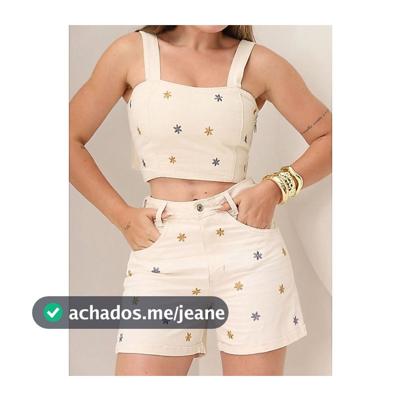 Conjunto feminino de duas peças em jeans com bordado floral sem mangas, composto por blusa cropped e shorts curtos.